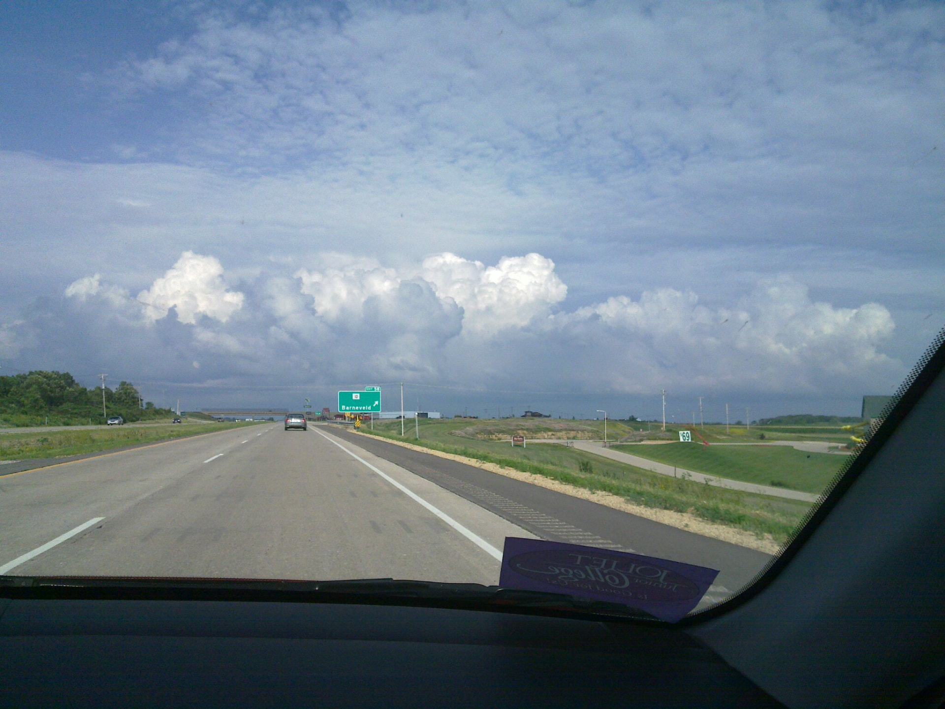 Uitzicht door de voorruit op een snelweg in Wisconsin met stapelwolken