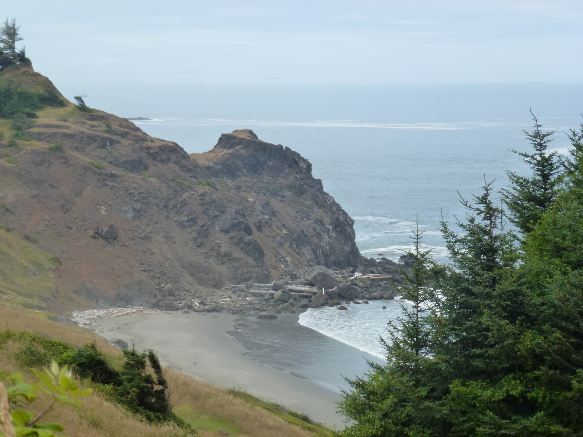 Rotsige klif met een verscholen zandbaai aan de kust van Oregon