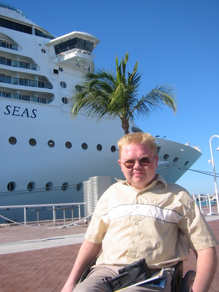 Freek in de rolstoel voor een groot cruiseschip in de haven van Miami